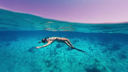 Brunette Woman Swimming Underwater in Turquoise Ocean