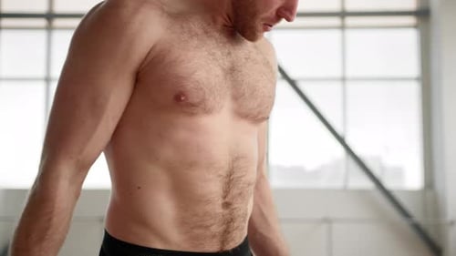 Joven atlético de unos 30 años realizando entrenamiento con pesas