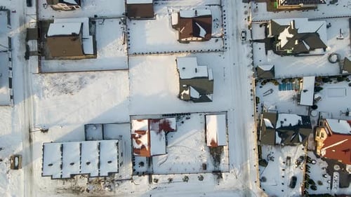Aerial View of Private Homes with Snow Covered Roofs in Rural Suburbs Town Area in Cold Winter