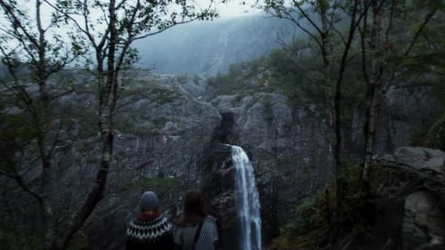 Drohnenaufnahme eines Reisenden mit Blick auf den Wasserfall