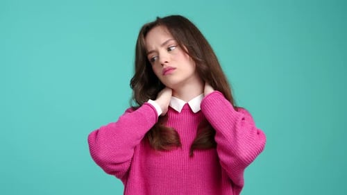 Young Woman Rubbing Stiff Neck in Studio