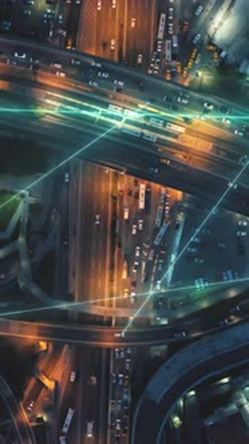 Plan panoramique de haut en bas d'un échangeur autoroutier à plusieurs voies et à plusieurs niveaux très fréquenté la nuit | Effets visuels