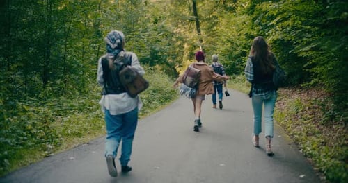 Carefree Male And Female Explorers Walking In Forest