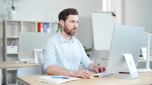 Man Working on Computer in Bright Office