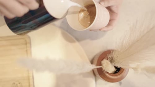 Milk Being Poured Into Cup of Coffee