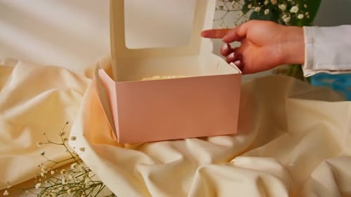 packed delicious cake in gift box on beige background man opens box and shows sweet dessert