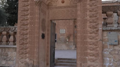 We see the main garden entrance made of pink stone of Latifiye Mosque of Mardin. The camera shows al
