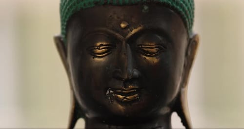 Zoom in on a Buddha statue from close up. Spirituality, meditation and third eye opening concept. 4k