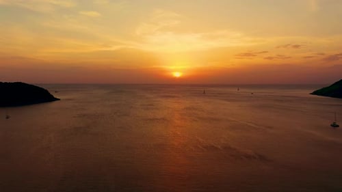 Orange sunset over the sea. The sun is setting over the horizon. Evening view of the mountains and s