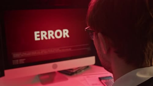 Man Working at Computer with Error Message