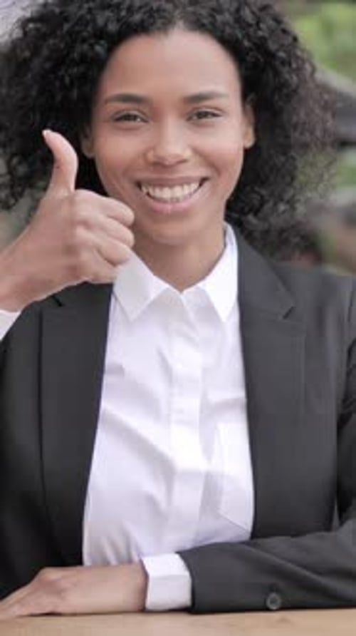 Thumbs Up by African Businesswoman Sitting in Outdoor Cafe, Vertical Video