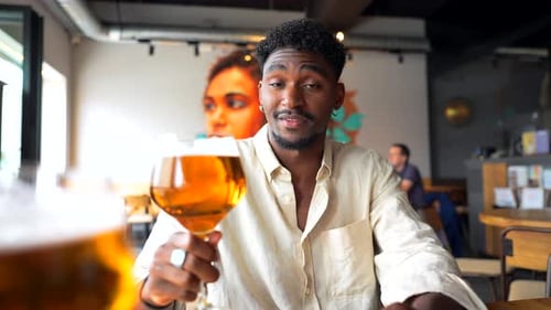 Stylish Man Enjoying Craft Beer in a Modern Pub