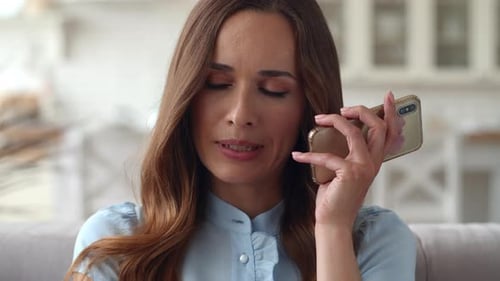 Sad woman speaking on phone at home office in slow motion portrait