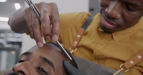Barber Shaving Hairline With Straight Razor Close Up