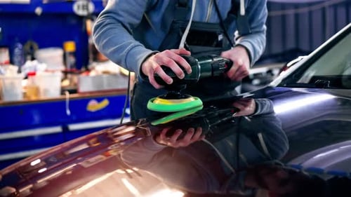 Closeup of the Hands of a Car Mechanic at a Service Station Doing the Final Polishing to Shine