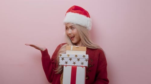 Porträt einer glücklichen kaukasischen jungen Frau mit Weihnachtsmannmütze mit Geschenkbox