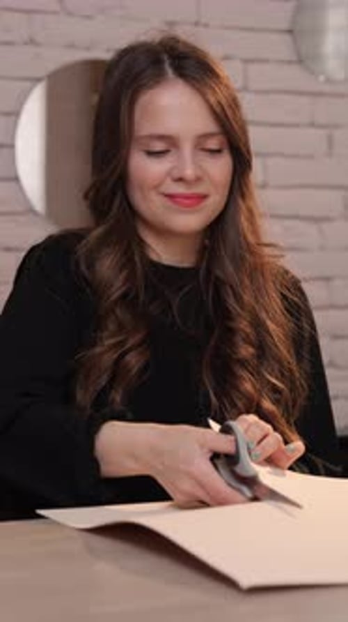 A Woman Diligently Cuts Paper Demonstrating Her Artistic Creativity