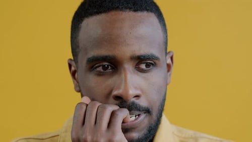 Man Biting Nails, Close Up, Yellow Background