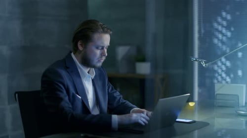 Successful Young Businessman Sits in a Private Office At His Desk and Works on a Laptop. His Offic