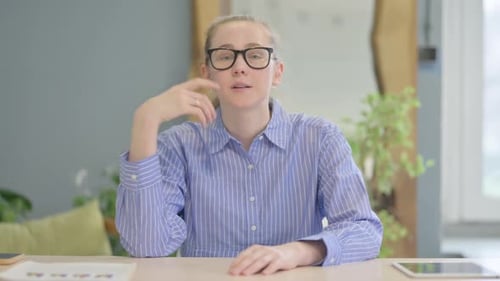 Young Woman Talking at Her Desk