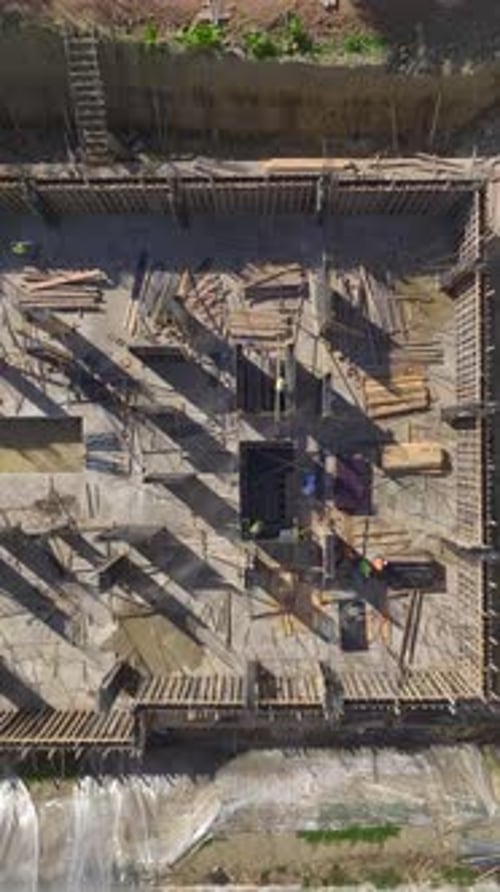 Vertical Video Construction Workers Build Walls on a Busy Site with Energy and Precision in Every