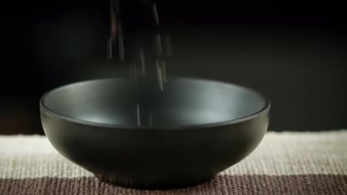 Black Grains Pouring Into a Bowl