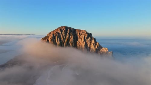 A Majestic Rock Formation Majestically Rising Impressively Above the Clouds in California