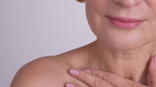 Woman Touches Face and Neck in Studio Close Up