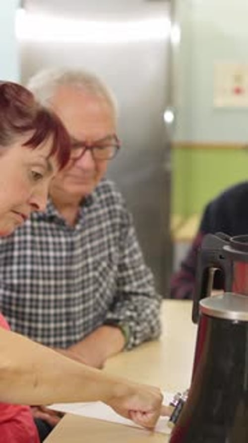 Woman Explains Document to Man Indoors