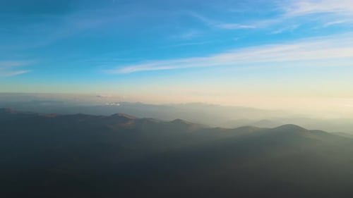 Beautiful Mountain Panoramic Landscape with Hazy Peaks and Foggy Valley at Sunset