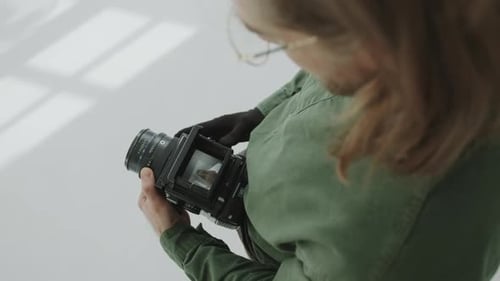 Photographer Examining Portraits through Viewfinder of Medium Format Camera