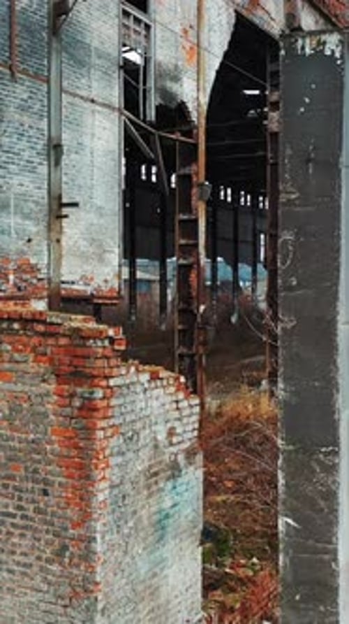Abandoned industrial building. Ruins of an old factory. Aerial view. Vertical video