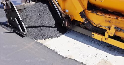 Asphaltpflastermaschine und Dampfstraßenwalze bei Straßenbauarbeiten (Schichteinbringung)