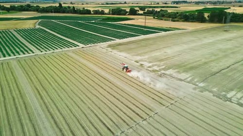 Tractor Working in a Field Surrounded by Farmlands - Aerial View