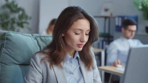 Focused Attractive Businesswoman Look at Camera Working on Laptop Computer in Office On Background