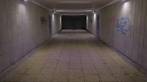 Walking in the underground passage in the night, graffiti