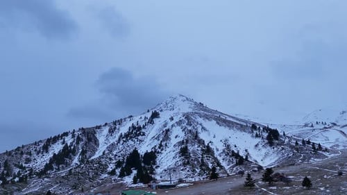 Zumbido del paisaje nevado del pico de una montaña en Helmos, Grecia, 4K