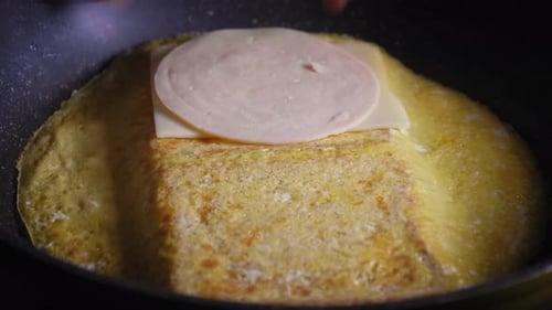 Making egg and cheese toast in pan folding it together and letting it cook (partial timelapse)