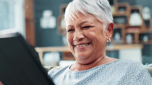 Smiling Senior Woman Using Tablet at Home