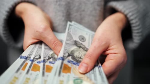 Woman Counts Stack of One Hundred Dollar Bills