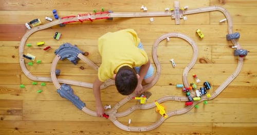 Boy Playing With a Toy Train at Home
