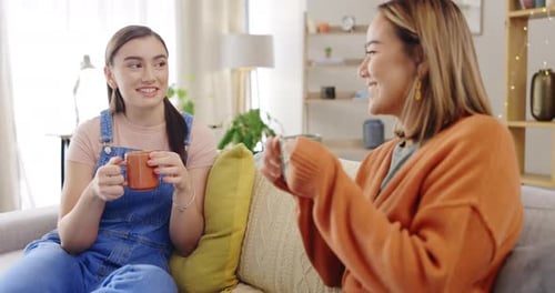 Two Young Women Chatting Together Indoors