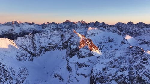 Breathtaking aerial view of the snow-covered Alps during sunset
