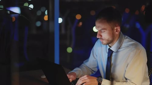 Young Man Working Late on Laptop in Office