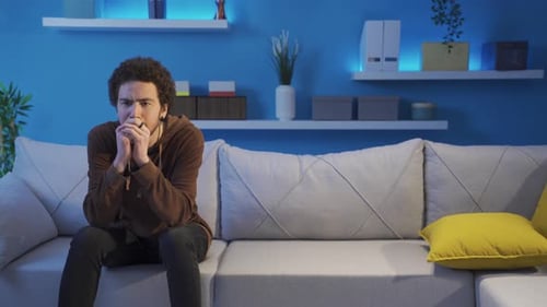 Un jeune homme déprimé et agressif rentre à la maison frustré.