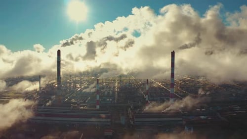 Power plant smokes. Aerial view of the power plant with smoking pipes and clouds passing by