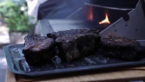 Thick juicy filet mignon steaks smoking on outdoor grill in backyard, close up shallow depth of fiel