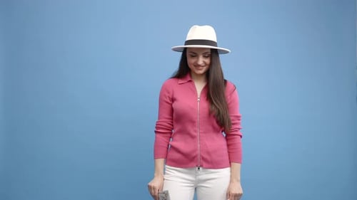 Woman Holding Cash and Candy, Standing on Blue Background