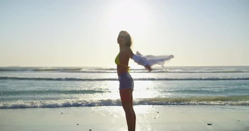 Smile, spinning and woman walking at the beach on holiday, vacation or travel in summer lens flare