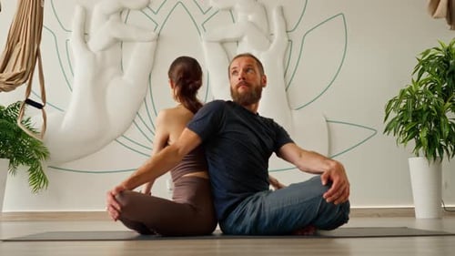 hombre y mujer practican meditación y estiramientos en la sala de yoga para equilibrar el cuerpo y relajarse